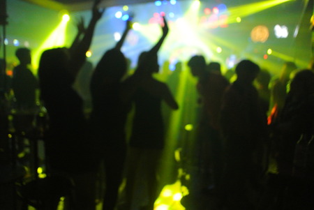 silhouette concert in front of stage.Defocused entertainment concert lighting on stage, blurred disco party.の写真素材