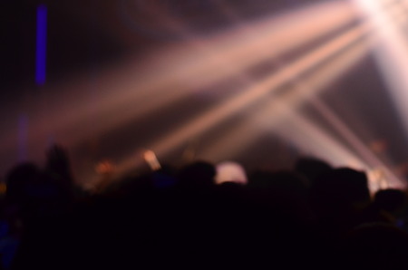 silhouette concert in front of stage.Defocused entertainment concert lighting on stage, blurred disco party.の写真素材