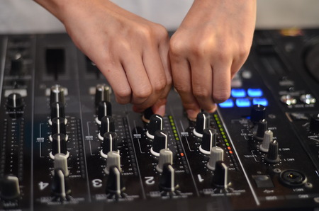 Dj mixes the track in the nightclub at party