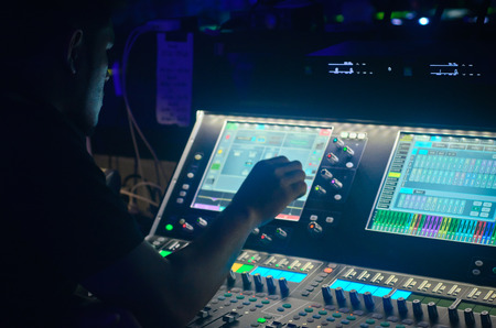hand of sound engineer on the sound mixer,Sound engineer working at mixing panel in the boutique recording in pubの写真素材