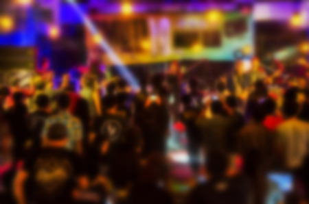 blurred night club party festival with crowd of people for background