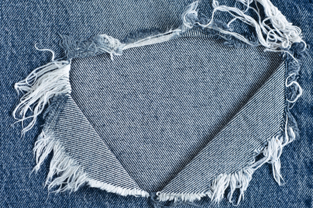 Denim background texture for design.torn old blue jeans backgroundの写真素材