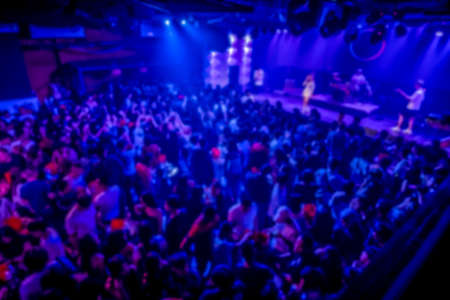Out of focus abstract silhouette people dancing in a crowd. Flashes of light.の写真素材
