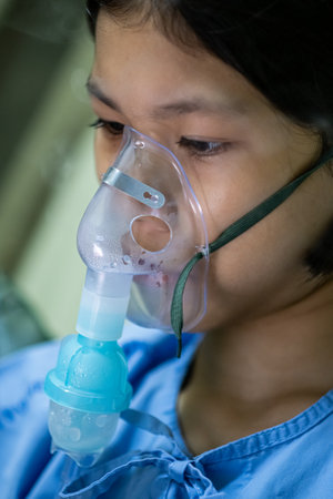 Close up sick Yong asian girl with face oxygen mask,on bed in hospital, Healthcare workers in the Coronavirus Covid19 pandemicの写真素材