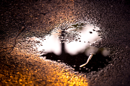 Reflection water on street after rainy in sunsetの写真素材