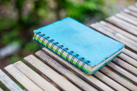 Old diary for memory place on bamboo wall,Blue note bookの写真素材