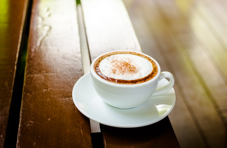 wonderful cappuccino coffee in white cup on woodenの写真素材