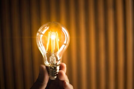 A hand holding is light bulb for save energy. Creative ideas concept, lightbulb for new idea, object design for thinking.の写真素材