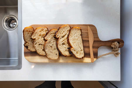 slices of wheaten bread and knife on wooden surfaceの写真素材
