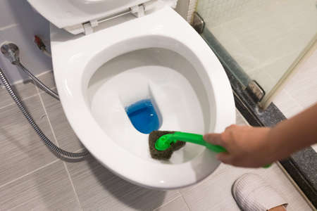 Hand of woman in glove cleaning toilet bowl using brush, concept for house cleaning and Preventing Coronavirus COVID19の写真素材