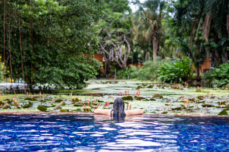 Summer lifestyle in an infinity pool, taking photos of women facing outside the pool.の写真素材
