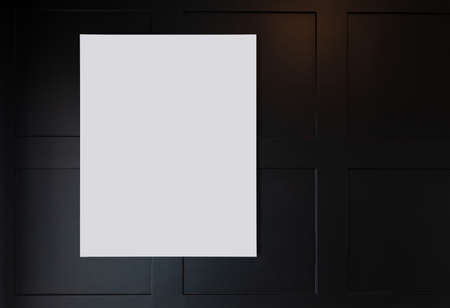 White frames with passepartout, hanging on the dark wall background.