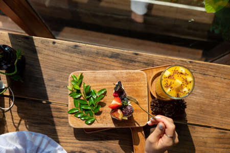 Fruit cake decorated with figs, cookies and blueberries with iced fresh mango smoothies glassの写真素材