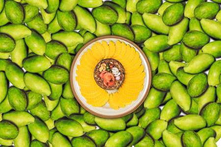 Raw green sour mango slice with Thai sweet fish sauce dip.made with coconut sugar put prawn, paprika...