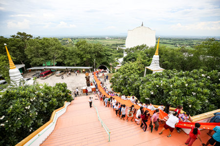 Lop Buri,Thailand. AUGUST 22 2020. :big blanket yellow robe to cover chedi.Monk and thai people doing ceremony fabric blanket cover chedi  at Wat Tham Phrathat Khao Prang, Lopburi province, Thailandのeditorial素材