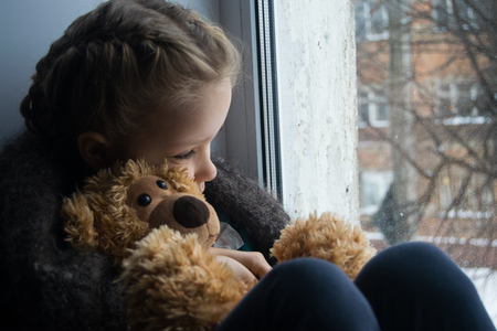 Baby emotion. Little girl with teddy bear The child was expecting parents.の写真素材