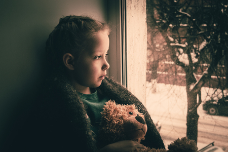 Baby emotion. Little girl with teddy bear The child was expecting parents.の写真素材