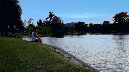 woman meditating on lakesideの素材