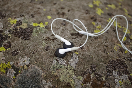 white earphones on moss-covered stone. Close up. Karpatianの写真素材