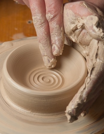 hands of a potter, creating an earthen jar on the circleの写真素材