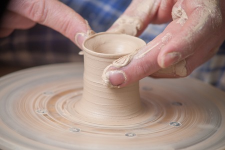 Hands of a potter, creating an earthen jar on the circleの写真素材
