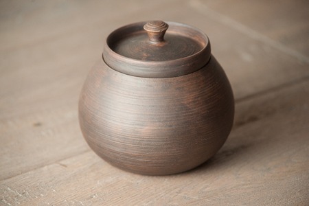 Traditional handcrafted brown pot with a capの写真素材