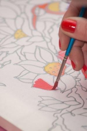 A woman hand with pencil is drawing picture with flowersの写真素材