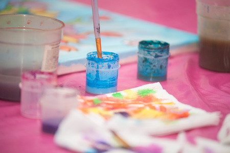 Watercolor paint in plastic cans on the pink table.の写真素材