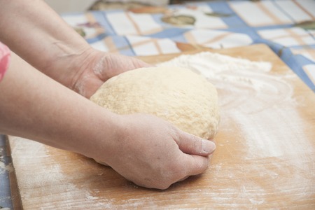 Ball of pizza dough with flour on the wooden tableの写真素材