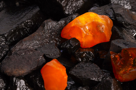 natural amber. A piece of yellow and red translucent natural amber on a piece of stone wood