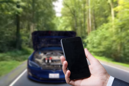 Man use mobile phone, blur image of the car is broken down as backgroundの写真素材