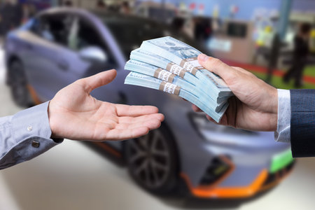 Purchase deal of buy or rent new car. Hand with dollar money and car keys. financeの写真素材