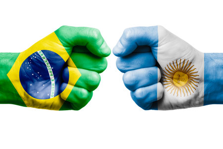 BRAZIL vs ARGENTINA confrontation, religious conflict. Men's fists with painted flags of BRAZIL and ARGENTINAの写真素材