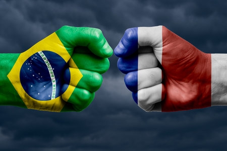BRAZIL vs COSTA RICA confrontation, religious conflict. Men's fists with painted flags of BRAZIL and COSTA RICA. Dark clouds backgroundの写真素材