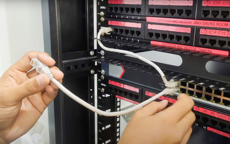 A man organizing server room wires and equipment for optimal performance in a data center.