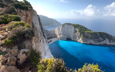 This breathtaking landscape showcases a remote beach surrounded by towering cliffs. The vibrant blue...