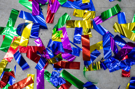 Multicolored festive confetti on the grey floor