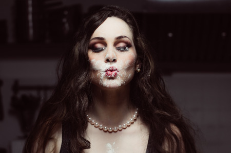 Portrait of beautiful hostess soiled in flour,  closed eyesの写真素材