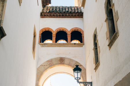 Old street with arch in Sitges, Spainの写真素材