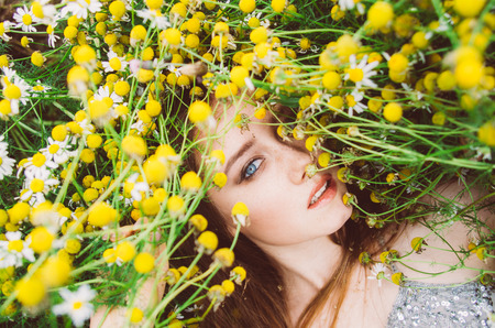 Portrait of young girl in chamomile fieldの写真素材
