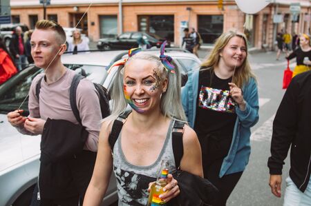 Helsinki, Finland - June 29, 2019: Young woman with friends with balloons on Helsinki Pride festival...