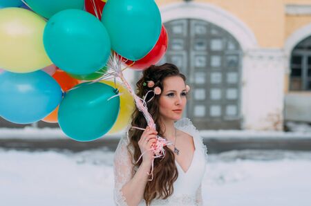 Smiling bride winth roses in hair and balloons in handsの写真素材