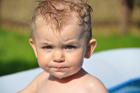 wet little boy with anger on his faceの写真素材