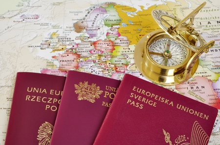 Polish, Portuguese and Swedish passport on a map with old compassの写真素材