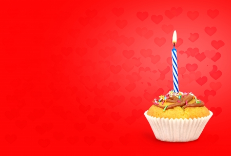 Birthday cupcake with candle on red hearts background Text space の写真素材