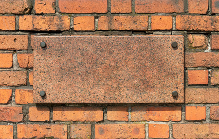 Granite board with metal pins on an old brick wallの写真素材