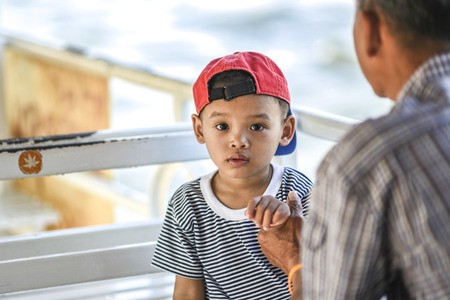 Bangkok, Thailand, March 4, 2016: Young thai boy with his granfather holding his hand.のeditorial素材