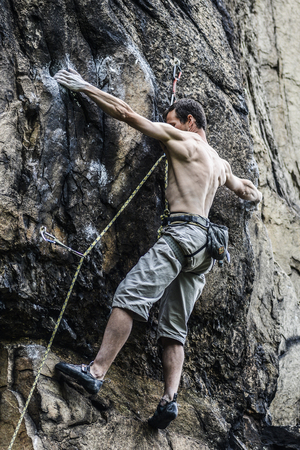 Young male climber leading a route on a rock. Sokoliki, Poland