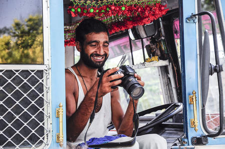 Amritsar, India, september 5, 2010: Indian truck driver watching a picture on a camera.