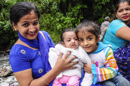 Dharamsala, India, september 6, 2010: Smiling indian family with little child in traditional clothes.のeditorial素材